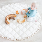 Bébé sur tapis d'éveil en coton blanc, 100cm, pliable, avec jouets en bois.