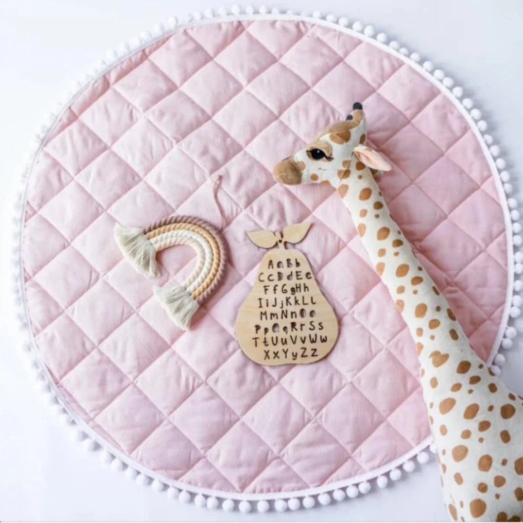 Tapis d'éveil rond en coton rose avec girafe et éléments ludiques.