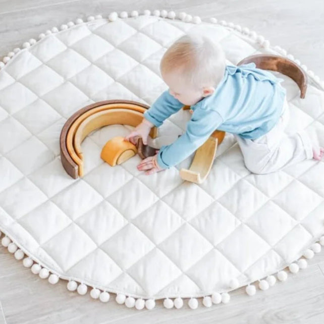 Bébé jouant sur un tapis d'éveil en coton blanc, 100cm, pliable.